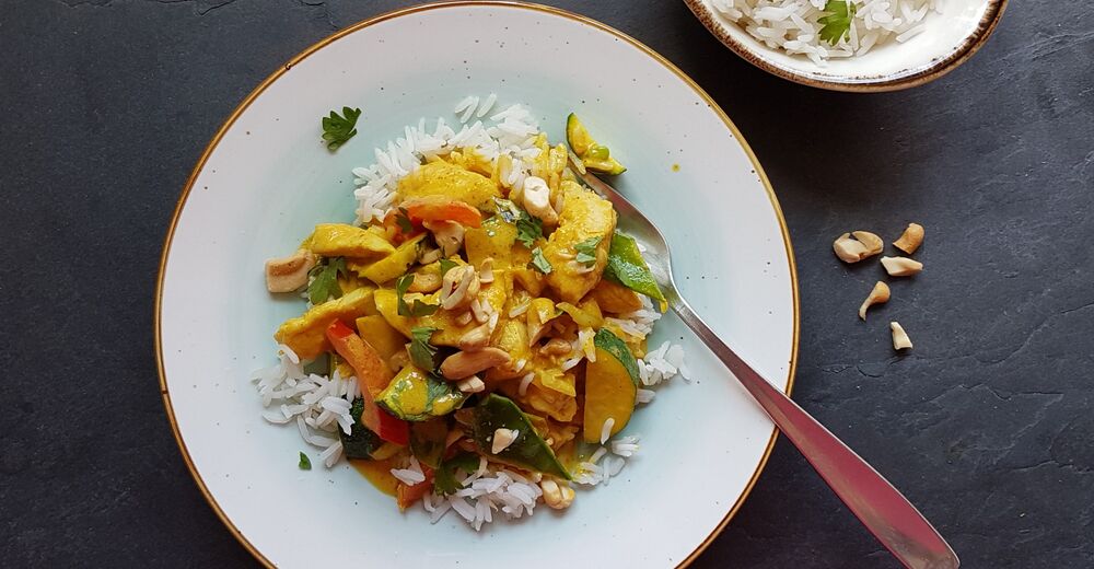 Gelbes Thai-Curry mit reichlich Gemüse und Hähnchenbruststreifen auf Jasminreis